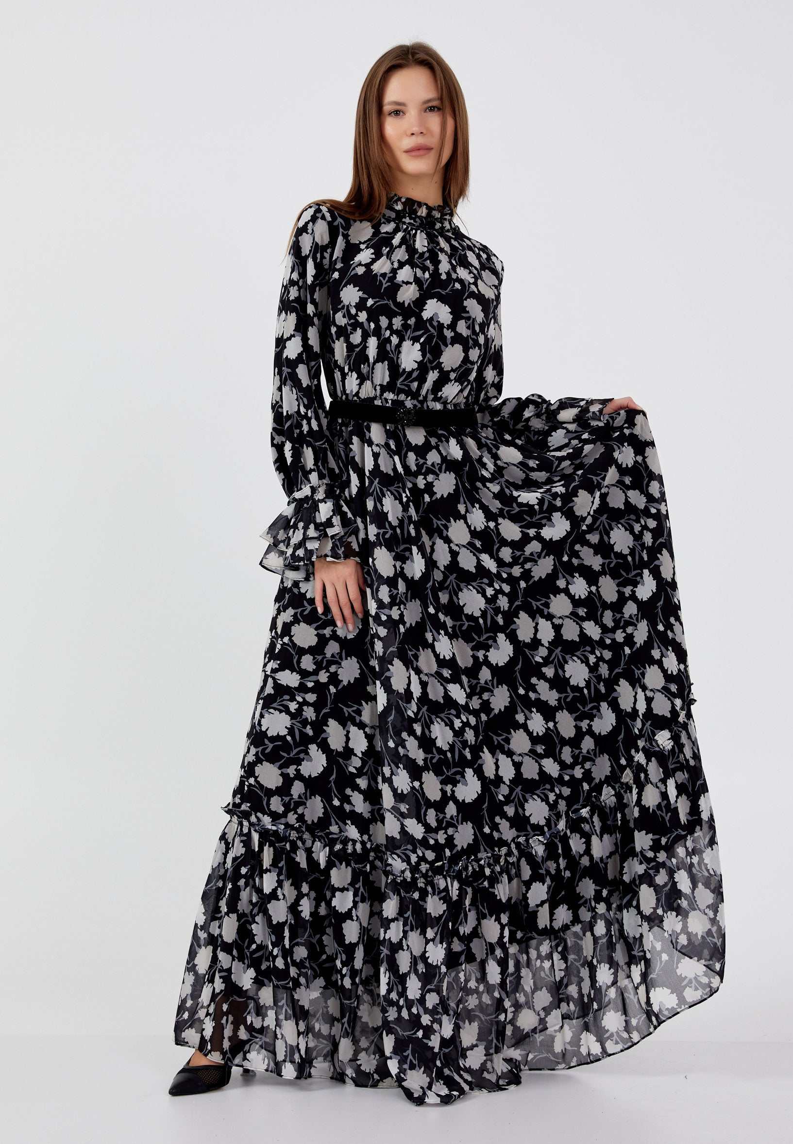 Elegantes florales Maxi-Kleid aus leichtem Chiffon mit schwarzem Grund und grauem Blumenmuster, hoher Ausschnitt und Stufenrock.